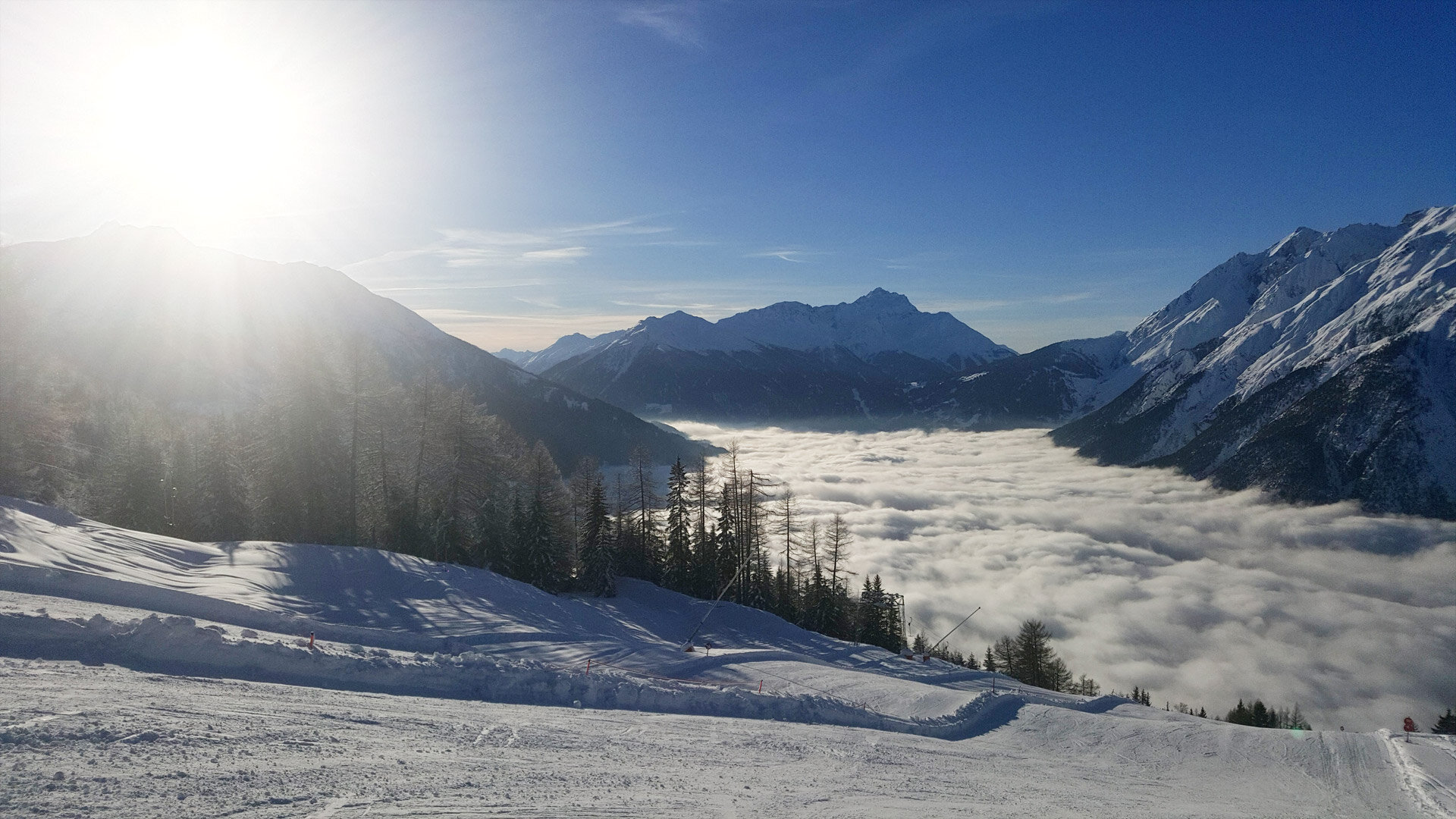 Foto: Blick ins Tal mit Nebel darüber Sonnenschein bei der Skihütte Zams in Tirol in Österreich.